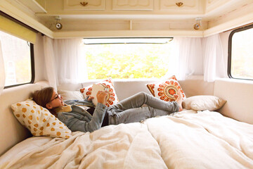 Fototapeta premium Teenager reading book in caravan