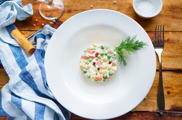Bowl of traditional russian salad on wooden table