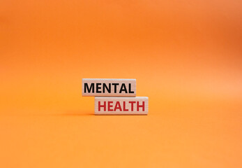 Mental Health symbol. Concept word Mental Health on wooden blocks. Beautiful orange background....