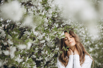 
portrait of a young girl with long hair and flowers on her head on the street. spring portrait. Awakening female beauty