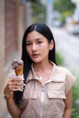A teenage girl wearing a vintage dress holds ice cream in her left hand and turns her head to look at the camera with a steady expression.