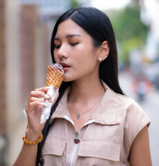 A young woman in a vintage dress is holding ice cream and is about to taste the cream. She looks cute.