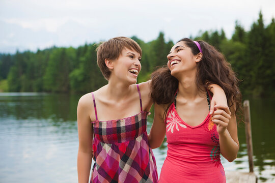 Two women laughing while enjoying a summer day at a lake. Walchensee, Germany