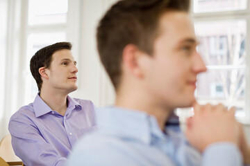 Young professionals at a start-up business listening to a motivational speaker and business coach holding a business coaching seminar.