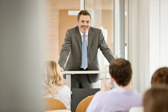 Motivational speaker and business coach holding a business coaching seminar for young professionals at a start-up business.