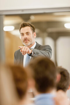 Motivational speaker and business coach holding a business coaching seminar for young professionals at a start-up business.