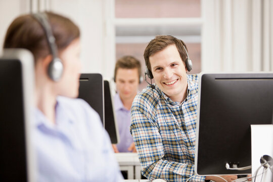 Colleagues working in a call center with a very friendly atmosphere. Munich, Germany - Powered by Adobe