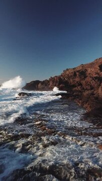Waves crashing on the cliffs, north of Gran Canaria, Canary Islands to drone in 4k, vertical plane