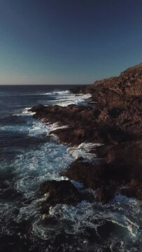 Waves crashing on the cliffs, north of Gran Canaria, Canary Islands to drone in 4k, vertical plane