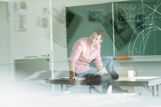 Portrait Lehrer im Klassenzimmer mit Reflexionen in Scheibe