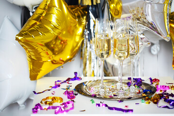 Close up of shiny glasses of champagne over black, white, golden and silver background