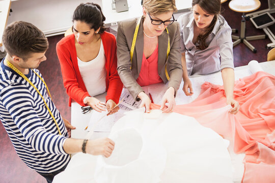 Seamstresses and tailor working on a new garment with sketch or croquis and pinning all together. Munich, Bavaria, Germany