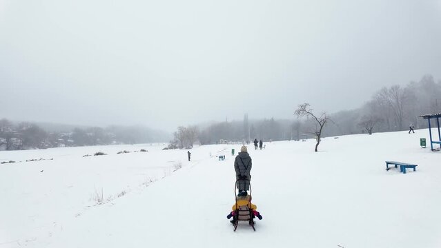 Сhildren riding on a sleigh in winter. slow motion