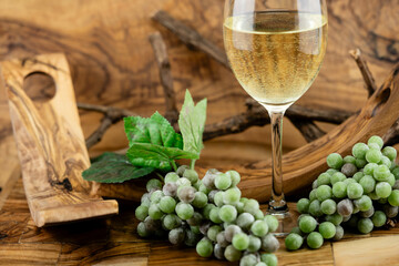 Weisswein und Trauben auf Olivenholz