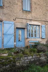 Fototapeta na wymiar facade of old village house with blue windows and door in french village