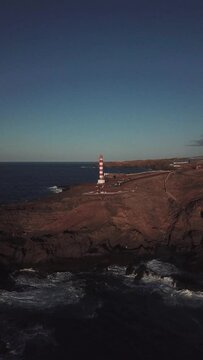 Sky, sea and mountain. Sardina de G&aacute;ldar lighthouse in Gran Canaria, vertical engraving with drone in 4k