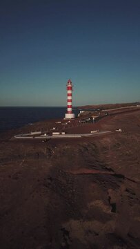 Sky, sea and mountain. Sardina de G&aacute;ldar lighthouse in Gran Canaria, vertical engraving with drone in 4k