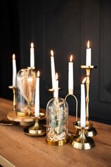 A decorated dining table or table in a restaurant. Installation of dried flowers and candles on a black background.