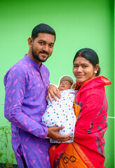 Portrait of a south asian young parents with their newborn baby girl 