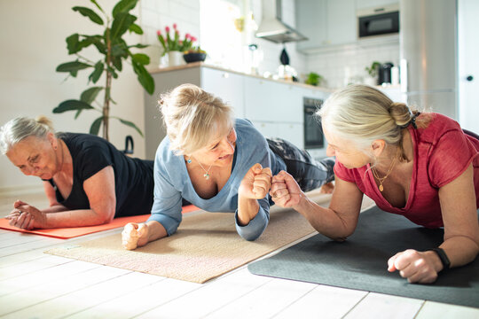 Senior women doing planks during group home workout