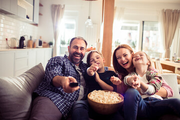 Happy family enjoying a movie with popcorn at home