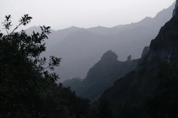 Foto op Canvas Misty mountain landscape on trail from El Cedro to La Hermigua in La Gomera, Canary Islands, Spain with famous Roques de San Pedro (Twin rocks of Hermigua), iconic rock formation. © Iwona