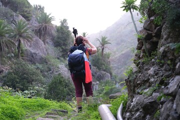 Hiking person taking photo on mountain trail from El Cedro to La Hermigua in La Gomera, Canary...