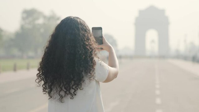 Indian Girl with Curly Hair Clicking Pictures of India Gate