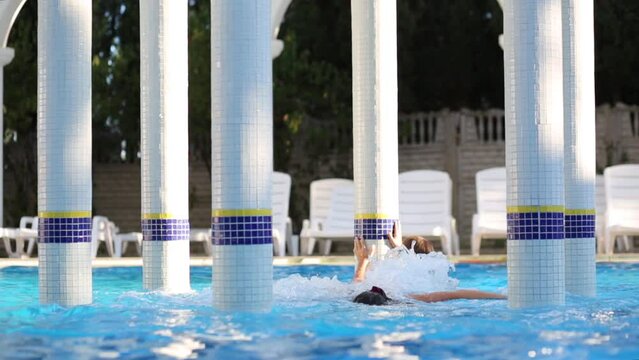 Woman and girl swim in pool with Jacuzzi and rotunda