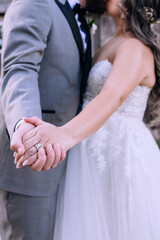 Couple holding hands and kissing, hands of bride and groom close-up, wedding ring for bride, couple on wedding day, touching moment, wedding ceremony, hands of lovers, wedding day