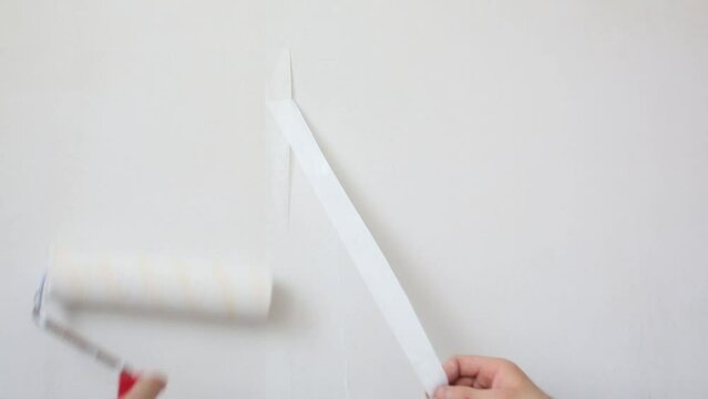 Worker removes excess fiberglass, next man spends roller on wall