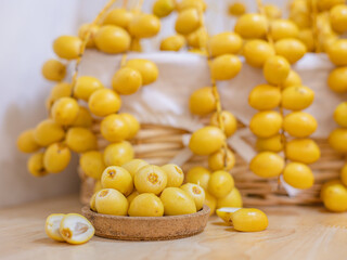 Close up and selective focus fresh dates fruits in wooden plate.
