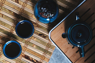Tableware for tea ceremony top view. Blue tea set pottery on bamboo napkin.