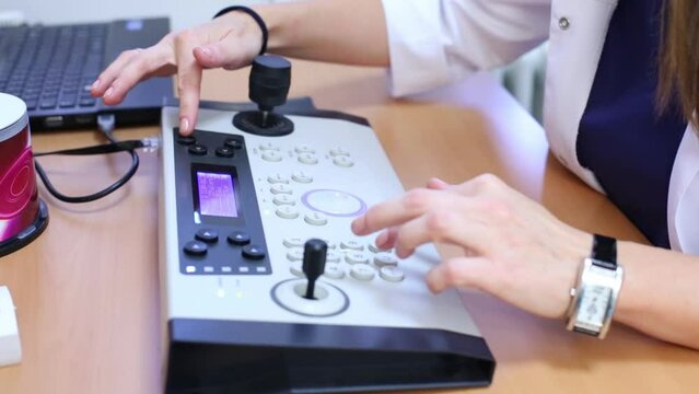 Close-up medical worker hands on the keyboard panel at table.