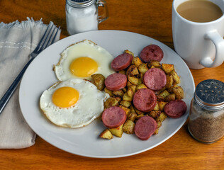 two fried eggs  with home fries and kielbasa