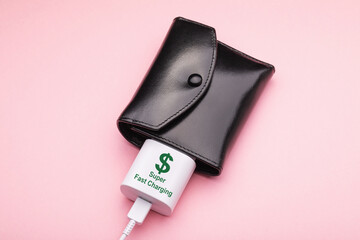 Wallet and smartphone charger on a pink background, concept on the topic of replenishing income or...