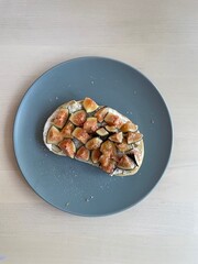 Plate on table features fresh figs on toast with copy space