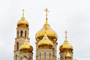 Domes of an Orthodox church against a cloudy sky, close-up