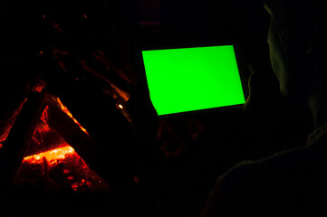 Tablet With Green Screen on Fire Background by Night
