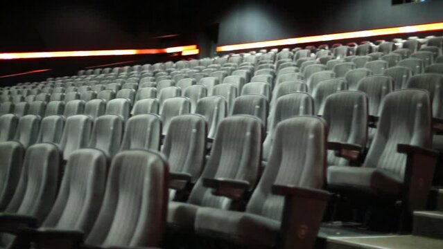 Rows of armchairs in empty cinema hall before film show start.