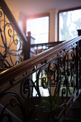 Staircase and railings with forged decor. Steps and metal pattern with bronze and gold patina....