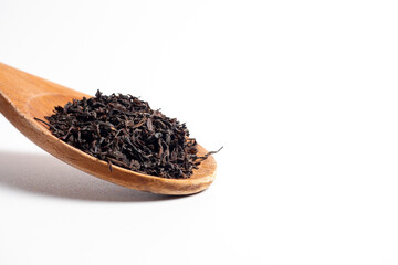 Close-up of Indian tea from Ceylon on a wooden spoon. Traditional product from India. copy space