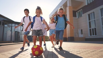 children near the school playing soccer. kids a school education kid dream concept. a group of...