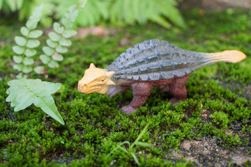 Toy dinosaur figurine in a real nature scenery outdoors
