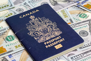 Closeup view of canadian passport and us dollar banknotes.