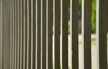 Close up view of a metal fence in perspective with blurred background