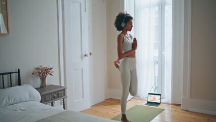 Fit model exercising yoga asana bedroom. Dark skin girl training flexibility - obrazy, fototapety, plakaty