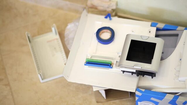 Home intercom package in open cardboard box on the floor.
