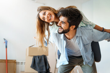 Shot of a young couple having fun while moving house. Young playful couple at their new apartment...