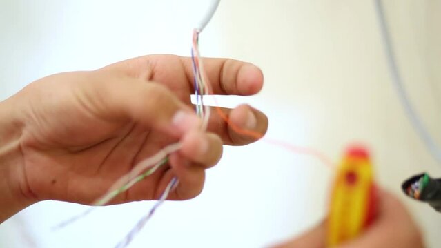 hands untwist twisted pair in cable during preparing to installation